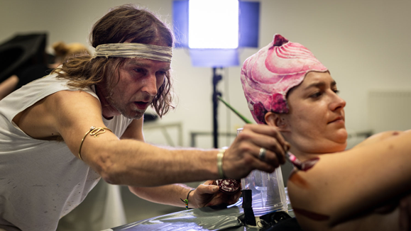 Hinter den Kulissen einer Bodypainting-Kreation: Ein Künstler trägt sorgfältig Details auf, um das fantasievolle Design zum Leben zu erwecken.